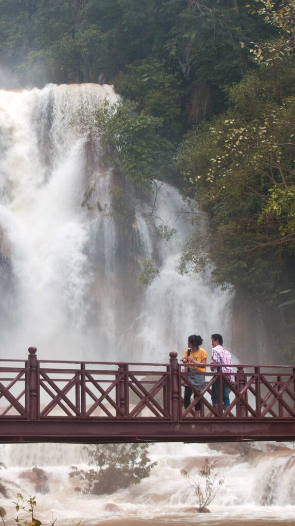 View of bridge in front of waterfall