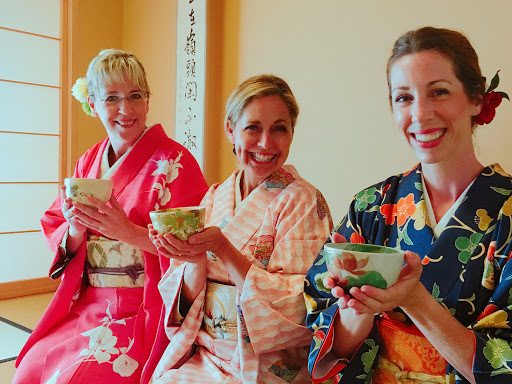 Three women in kimonos holding Bonsai plants